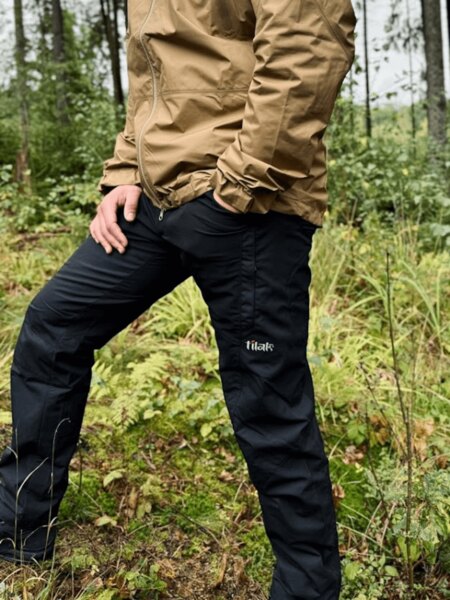 Bărbat în pantaloni negri de exterior Tilak în timpul unei expediții în pădure. Foto: Rigad