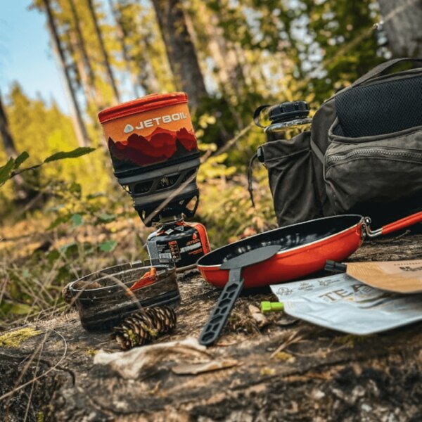 Arzător outdoor Jetboil cu tigaie și accesorii în pădure. Foto: Rigad