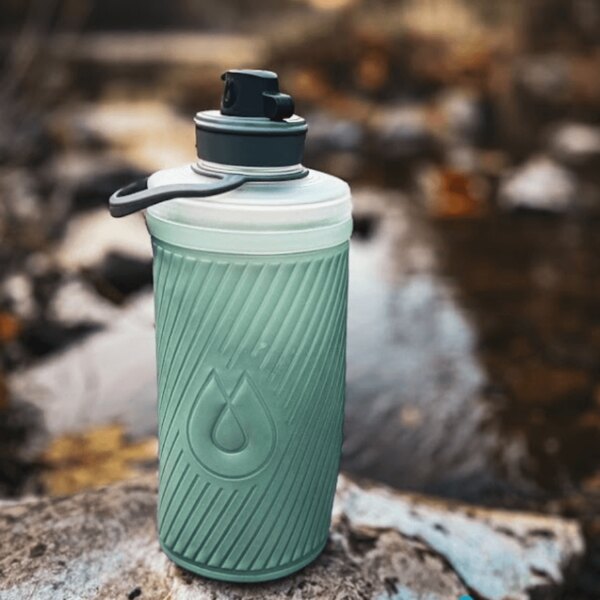 Sticlă pliabilă Hydrapak și filtru de apă utilizate la o sursă naturală. Echipament outdoor pentru hidratare. Foto: Rigad