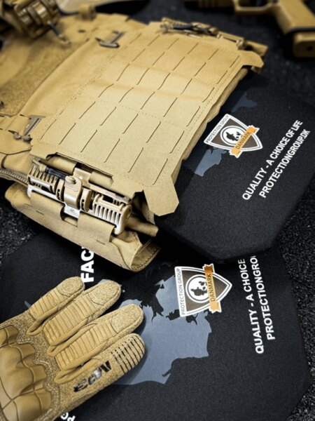 Vestă de protecție cu plăci balistice inserate, sistem laser-cut MOLLE și catarame de eliberare rapidă; în prim-plan mănuși tactice (PGD).