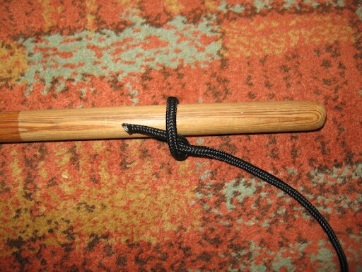 Bucla de lemn din șnur negru legată în jurul unui băț de lemn – un nod simplu pentru prinderea sarcinii