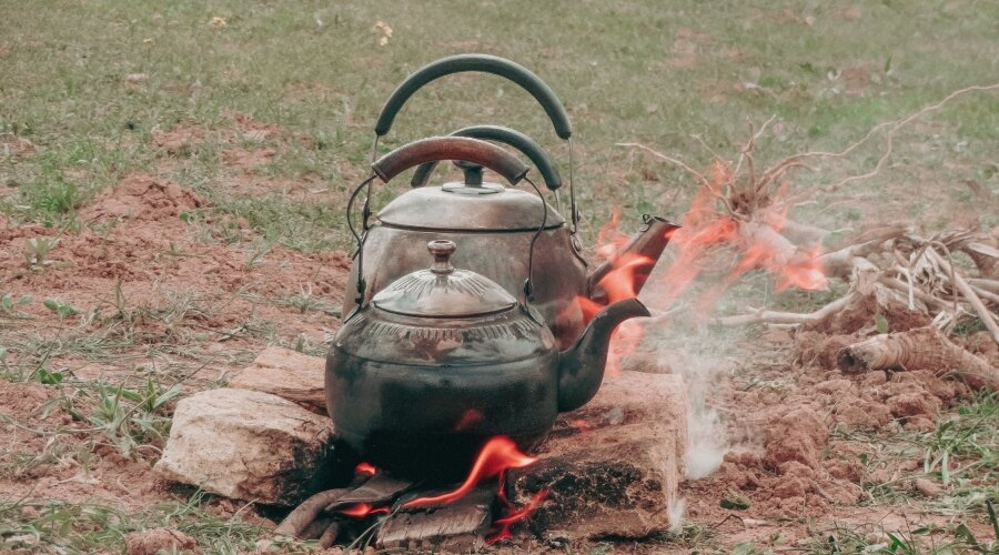 Ceainic care încălzește apa pe foc