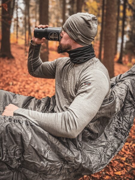 Un profesionist în aer liber așezat într-un hamac în timpul unei pauze în pădure, utilizarea practică a hamacului pentru dormit și relaxare în natură. Foto: Rigad.