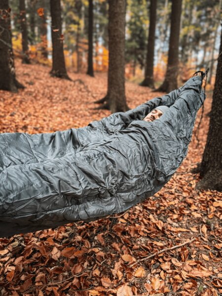 Hamac cu sac de dormit Cocoon atârnat între copaci, izolare pentru dormit în condiții reci în natură. Foto: Rigad