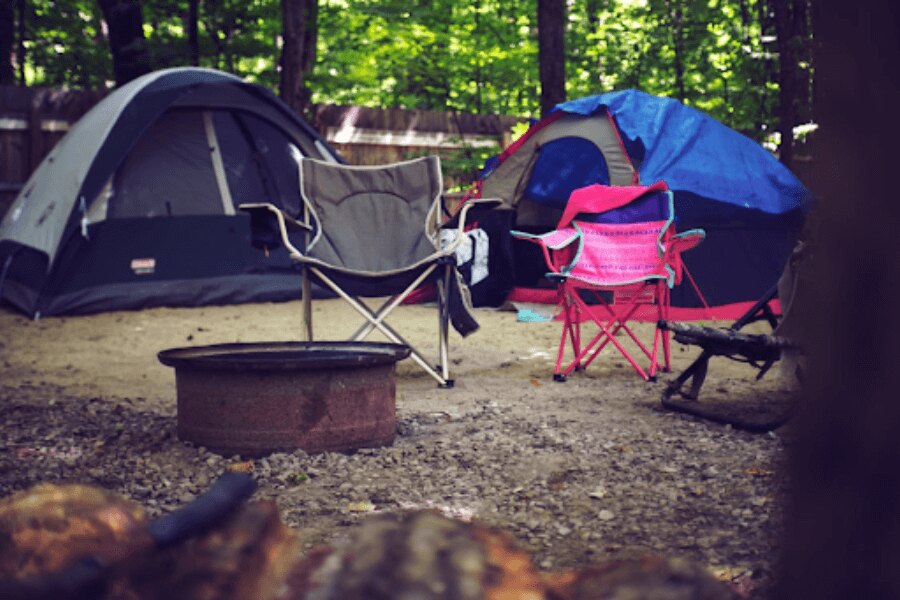 scaune de camping în fața cortului în camping. Sursă: https://www.pexels.com/cs-cz/foto/drevo-krajina-dovolena-leto-2662816/