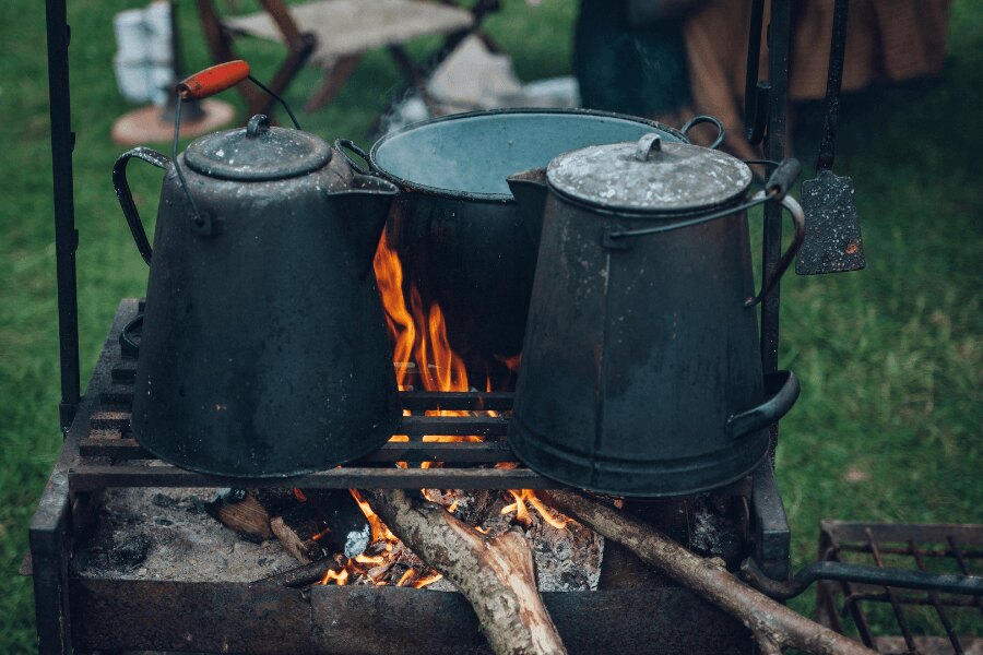 Ceainic și ceaun pe grătar în timpul campării. Sursă: https://www.pexels.com/cs-cz/foto/221436/