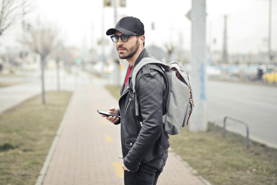 Bărbat pe stradă cu un rucsac și un telefon mobil. Sursa: https://www.pexels.com/cs-cz/foto/845457/
