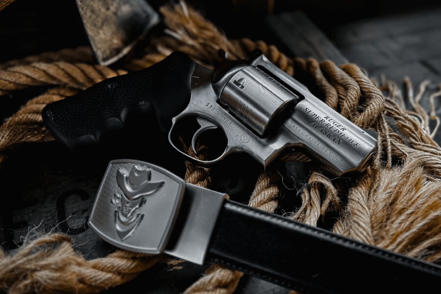 Revolver Ruger Super Redhawk Alaskan în calibru .454 Casull așezat pe o frânghie lângă o curea de piele.