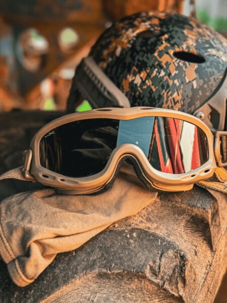 Ochelari de protecție tactici de tip goggles plasați pe echipament, în fundal cască; exemplu de utilizare în teren dificil. Foto: Rigad