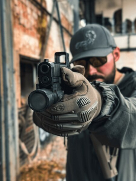 Trăgătorul țintește cu un pistol Glock cu colimator Aimpoint COA, vedere prin armă în practică, Foto: Rigad