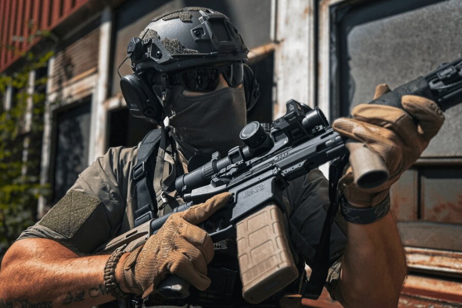 Trăgător cu o carabină AR-15 echipată cu optică în timp ce țintește pe teren, Foto: Rigad