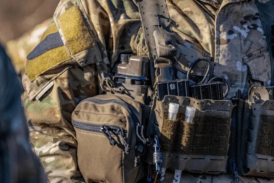 Detaliu al echipamentului tactic cu sticla de hidratare Qore Performance ICEFLASK® amplasată în suportul pentru plăci.