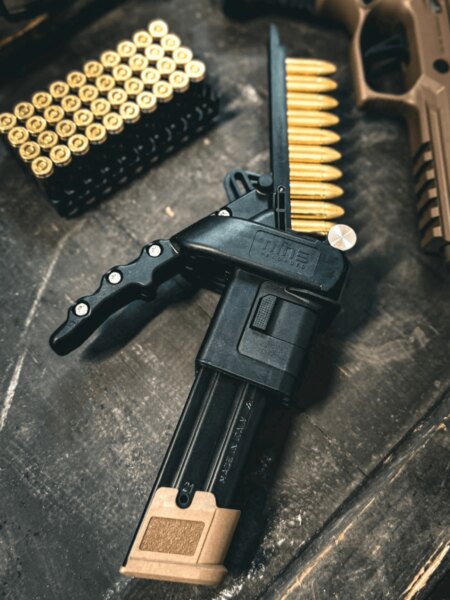 Încărcător Nine Reloaded lângă gloanțele de calibrul 9 mm Luger și pistol.