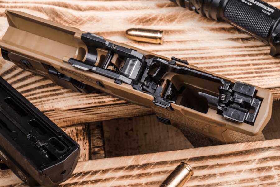 Pistol demontat Arex Delta Gen.2 OR cu mecanism de declanșare expus și componente interne.