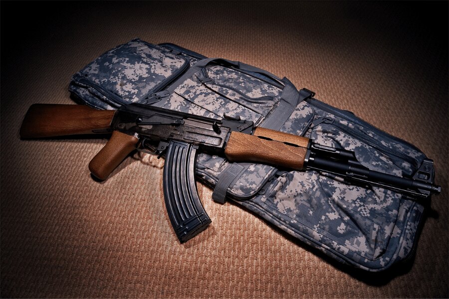 O replică airsoft a puștii AK-47 de la G&G Armament așezată pe o husă de arme căptușită.