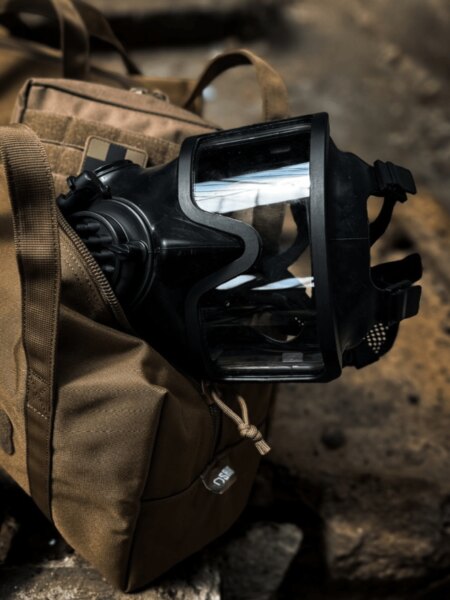 Detaliu al măștii de protecție faciale integrale AVEC cu vizor panoramic plasată pe rucsac.