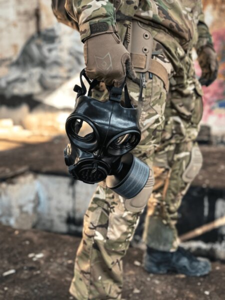 Detaliu al măștii de protecție integrale cu filtru ținută în mână.