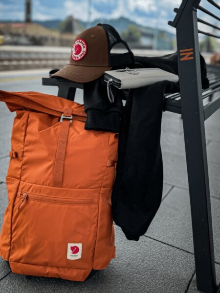 Rucsac portocaliu Fjällräven High Coast Foldsack 24 sprijinit de bancă